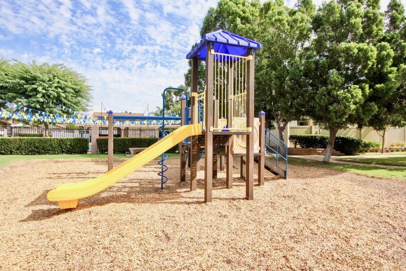 A yellow slide is attached to a playground set at a park at the Magnolia Meadows condos.
