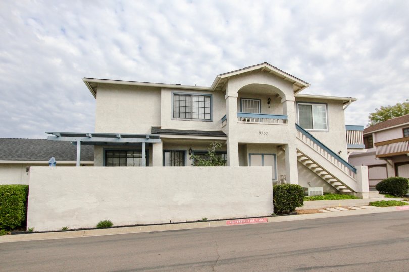 A home with white concrete walls in the Mission Martinique community of Santee California is seen on a cloud day.