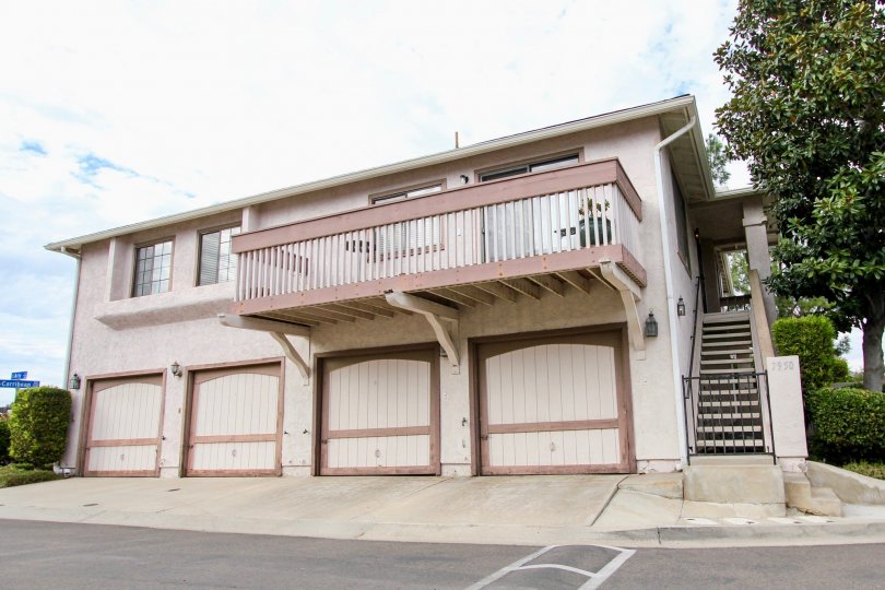 A view of four garage doors and a balcony on the second floor in the Mission Martinique neighborhood in Santee, California