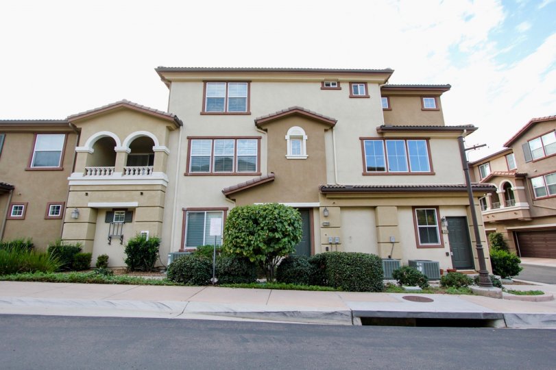 Three story building with a large green tree near a street in Northstar at santee CA