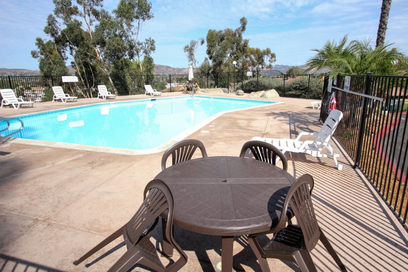 a pool in Riverwood Terrace with brown tables and white loung chairs