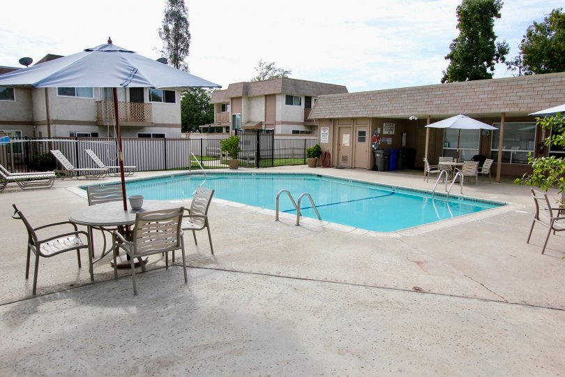 A shared pool area for an apartment complex in Santee, California featuring a clubhouse and concrete patio