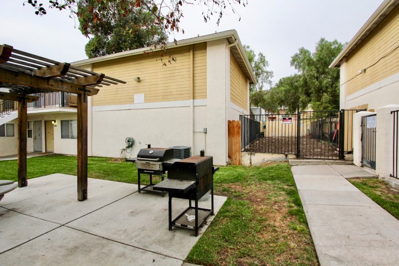 Concrete patio and walkways in a private fenced in area with barbeques and pergola in Spring Valley