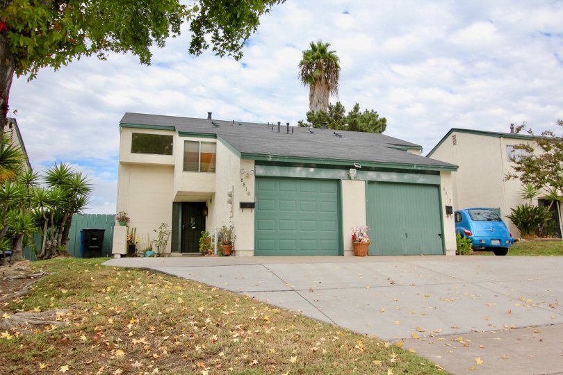 Duplex home with single car garage and pie shaped driveway with large sloping roof and front yard in Spring Valley
