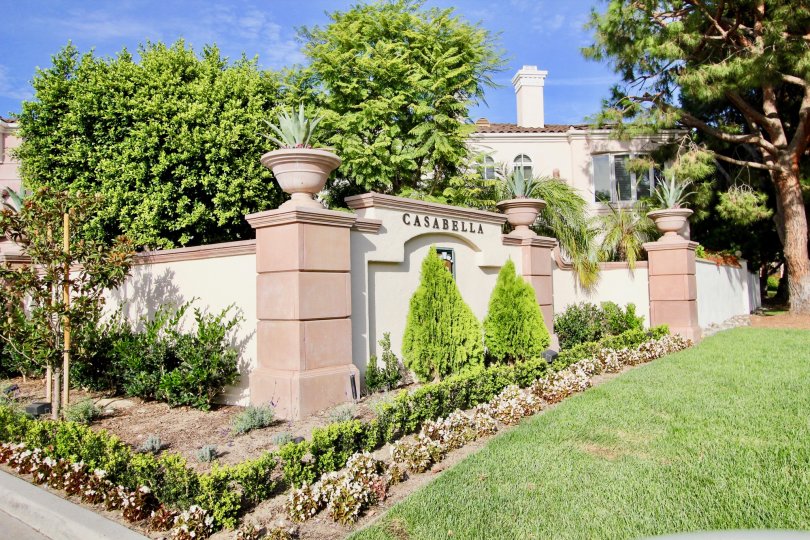 A SUNNY DAY IN THE CASABELLA HOUSE WITH LAWN, TREES, PLANTS.