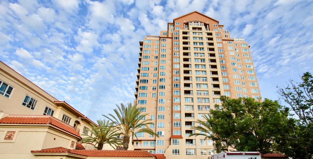 An exterior view of the Pacific Regent La Jolla high rise apartment building on a sunny day.