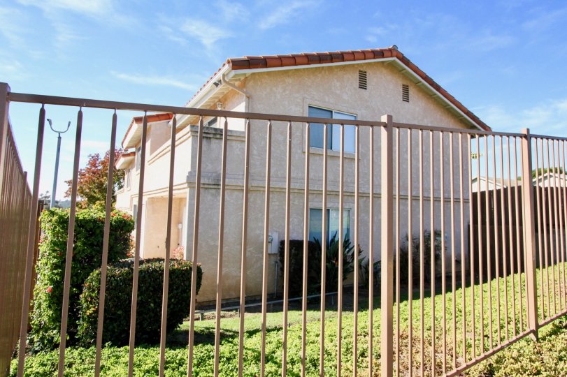 A sunny view of a fenced lawn with hedges in the Hillview Townhomes