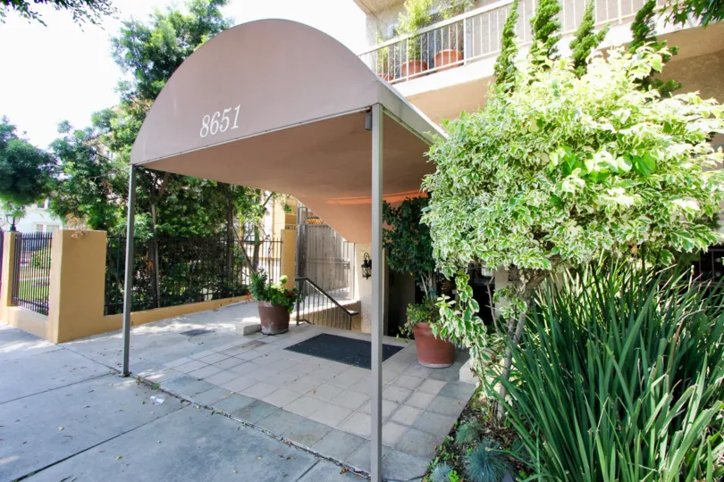 Canopied entrance surrounded by lush greenery at 8651 Olympic at the Beverly Center.