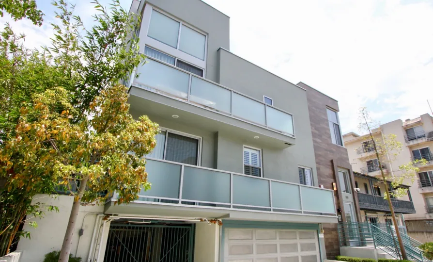 A bright day at One-O-Eight Croft in Beverly Center, California, with a view of a few trees and some balconies