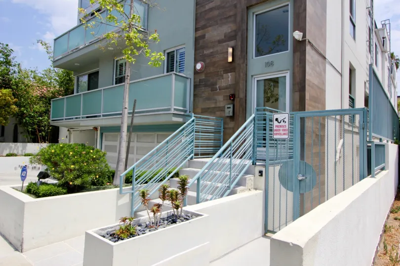 Entrace at One-O-Eight Croft with stairs and light blue railings. Light blue siding on personal terraces.