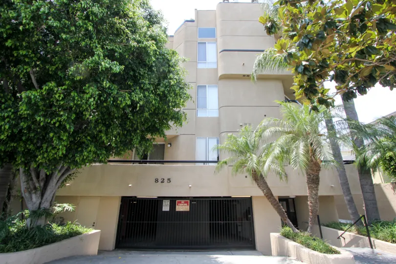 A sunny day at the Shenandoah Villas Apartments with trees and parking garage