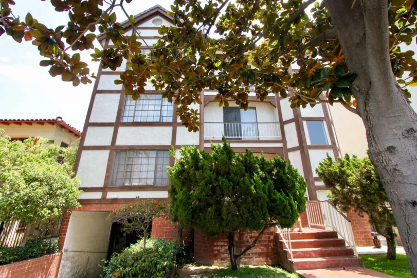Tall house in the Swall Tudor community with beautiful trees in front