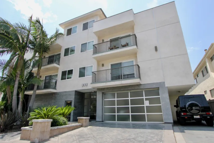 Street level view of the building at The 811, showing a garage and a resident's car.