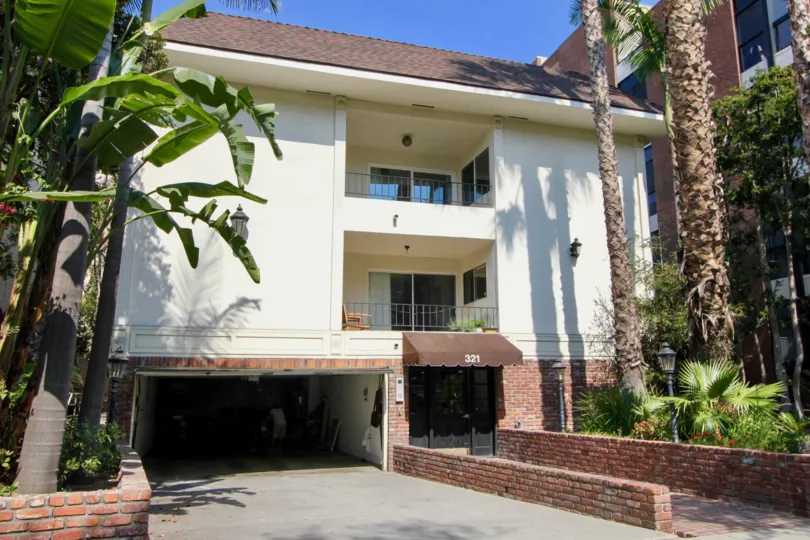 321 N Palm Dr house with banana trees and tall date palms.