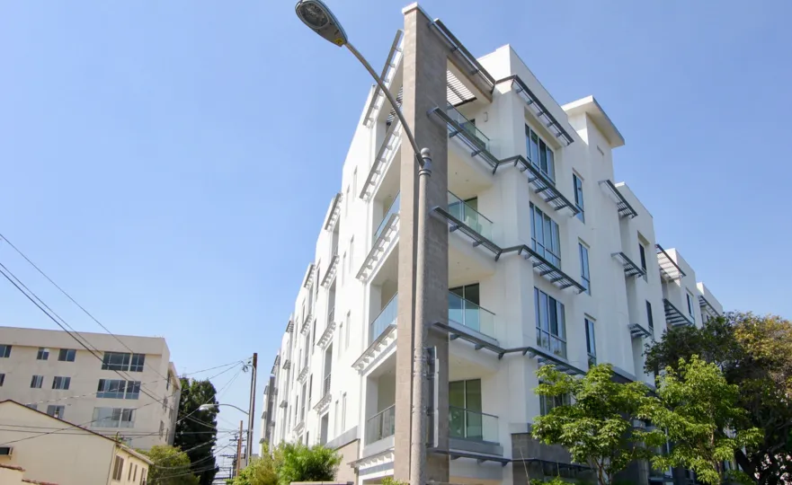 Street view of the Palm Condominiums in Beverly Hills on a clear sunny day