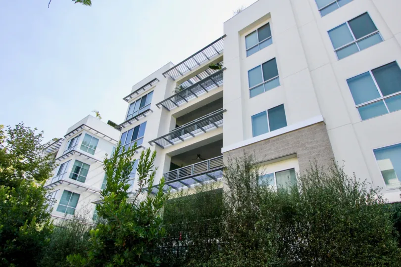 white building in Palm Condominiums with plants in the front