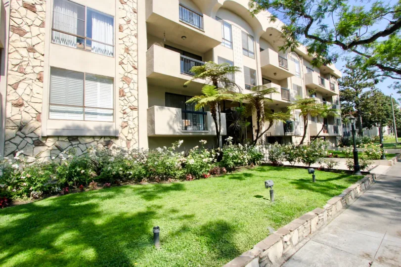 Building with 3 floors surrounded by trees inThe Beverly Palm Condominiums