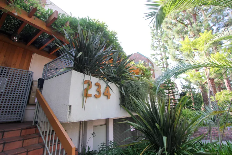 the front part of a house with a lot of plants in tower park