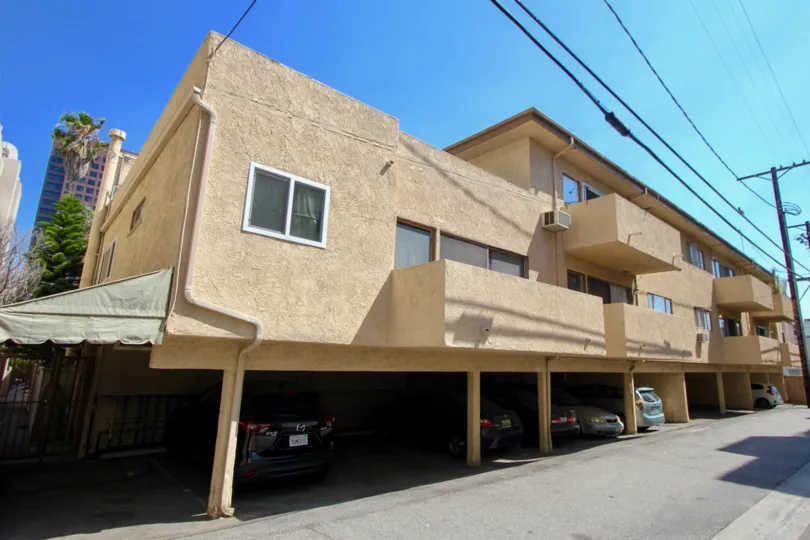Tan apartment building with spacious parking below in Brentwood, CA