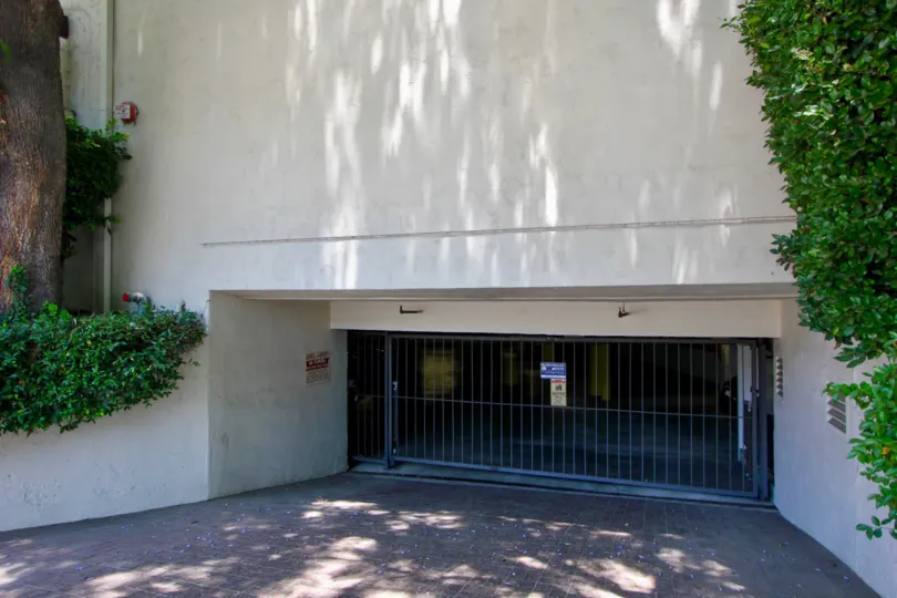 A wide underground garage with brick drively and steel security gate.