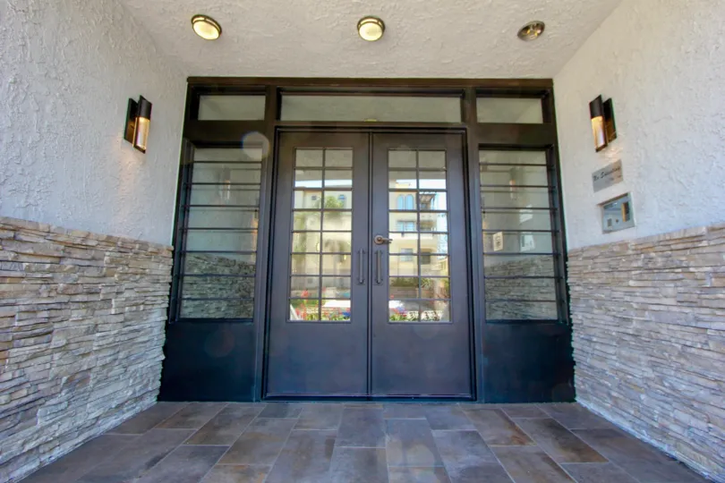 Wooden door entrance with brown tile at the Brentwood Cedar Tree