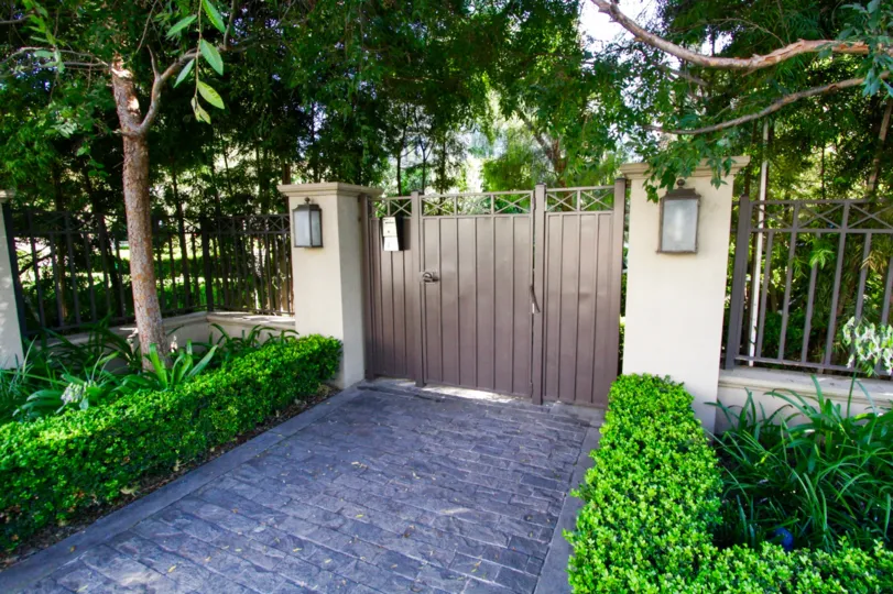 Cobblestones lead to the gated entry of Brentwood Garden Villas