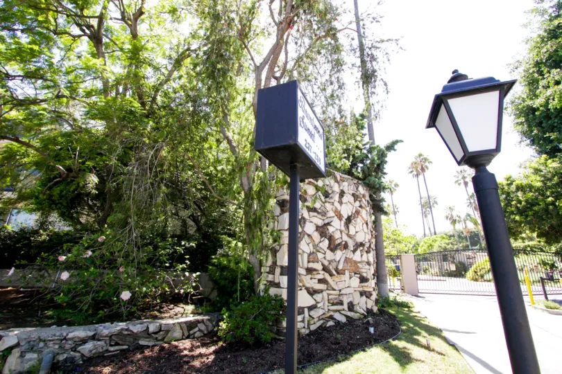 A large stacked stone wall is set in a planter outside of Brentwood Sunset