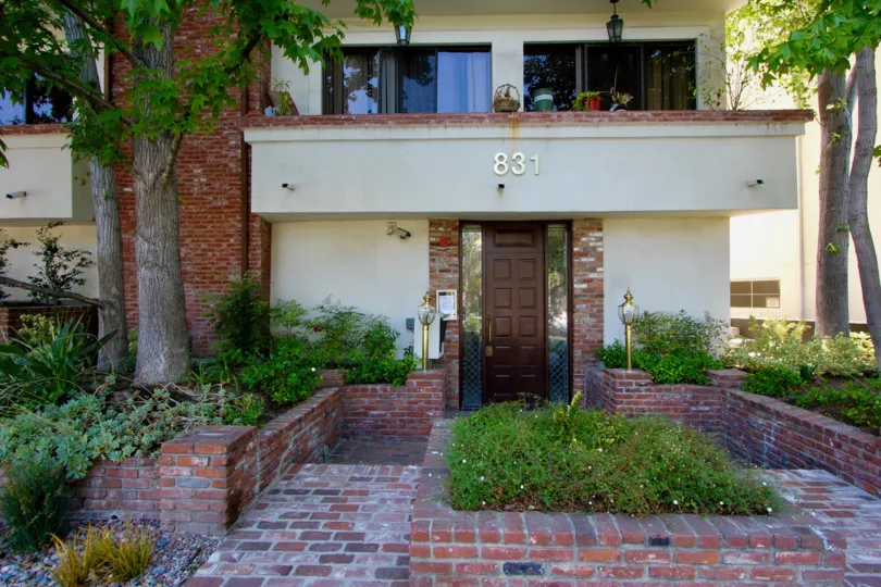 A pine tree stands in the front of the Brentwood Villas property