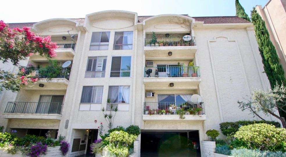 An apartment complex with multiple balconies and parking garage in Chateau Brentwood.