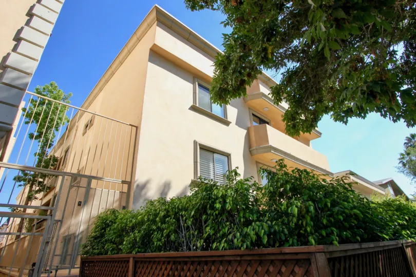 Chateau Gorham is a two story sandstone apartment building with separate balconies on each floor. It includes a fenced in yard, and a side gated area.