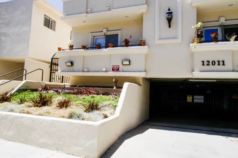 Raised planters filled with greenery in front of Del Cielo Condos