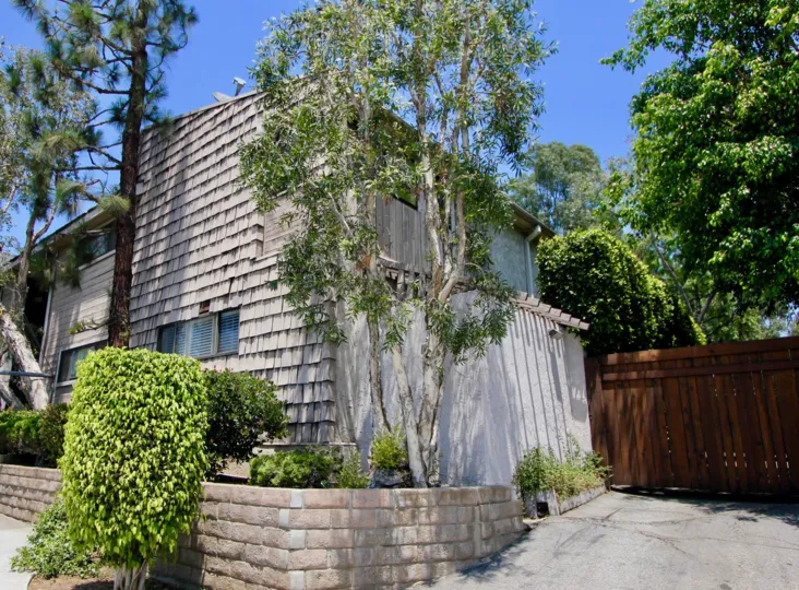 many trees around a large building in California with style