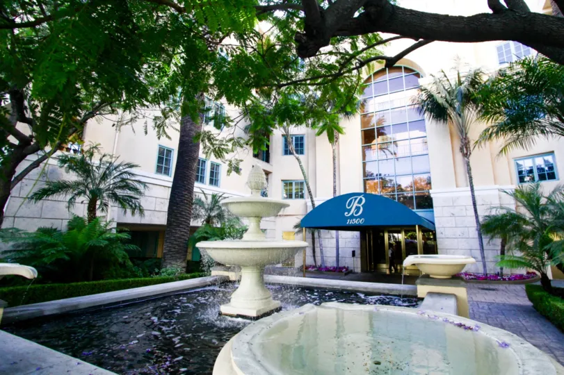A large fountain stands at the center of the courtyard at the Brentwood entrance