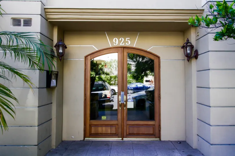 Arched wood doors lead to the lobby of the Westgate Place condos