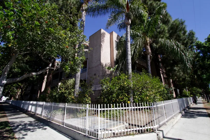 Corner view of Genesis showing a setback from the street and trees offering privacy