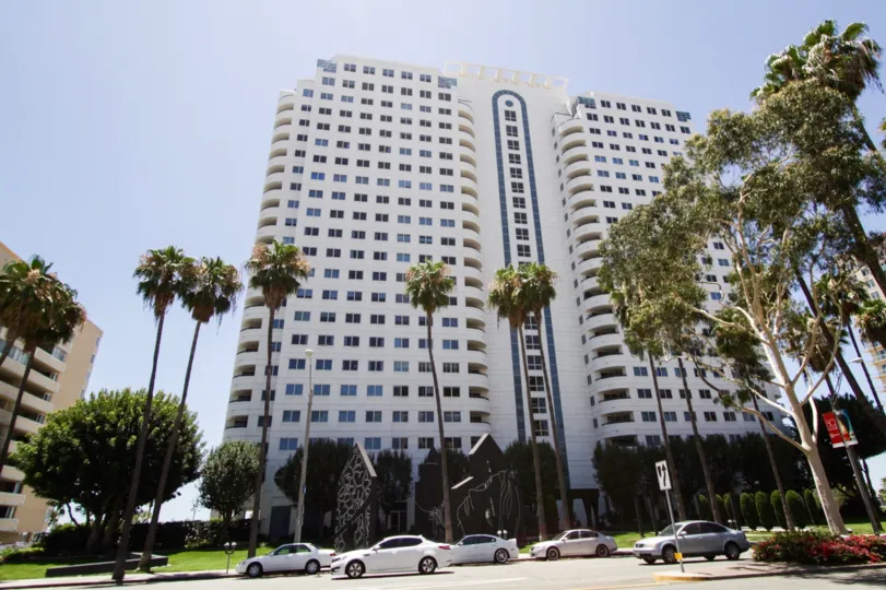Harbor Place Tower is a tall white condo building near the beach