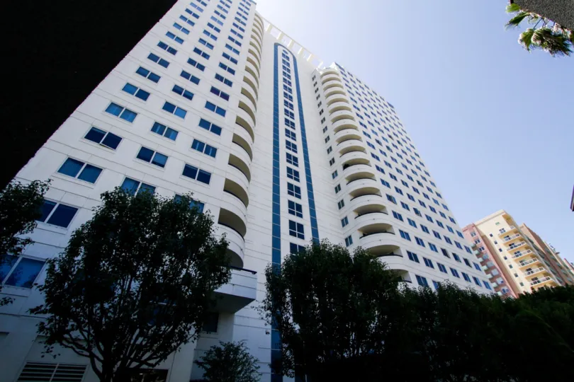 Looking up at Harbor Place Tower a white structure with blue accents