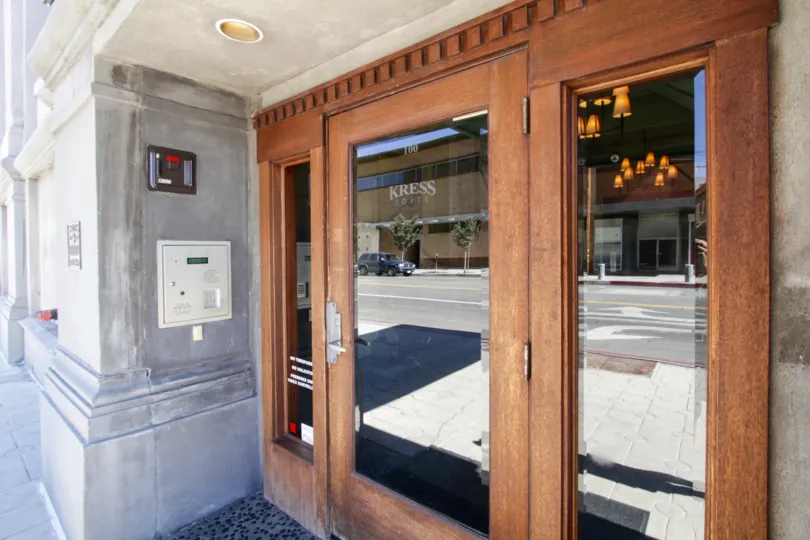 A wood door with glass insets leads to the entry to Kress Lofts