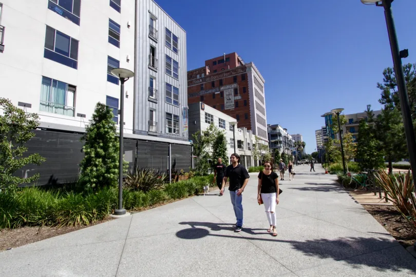People walk down the sideway in front of Promenade Walk