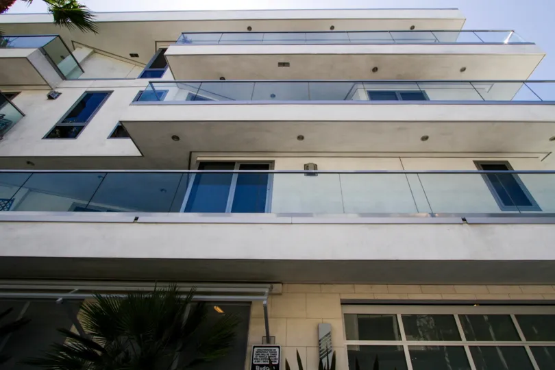 A long balcony with glass railing on second floor of The Oceanside
