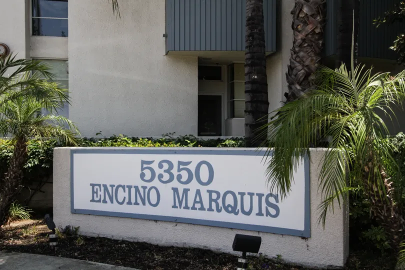 The sign showcasing the Encino Marquis building in the background