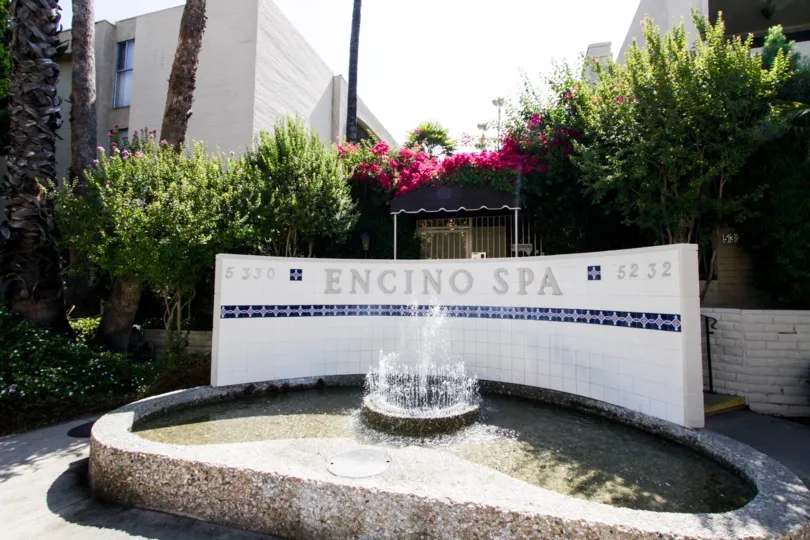 The sign along with fountain welcoming visitors to Encino Spa