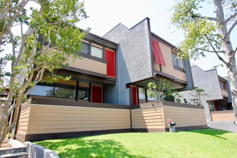 House with walls in two-tone layers of brown, some lighter than others, with red bars