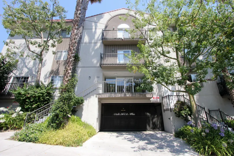 The front side of Manhattan Villas with large trees and wide open entrance