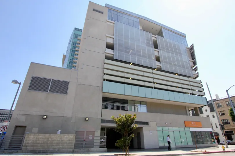 Modern building with square facade with a man waiting on his sidewalk