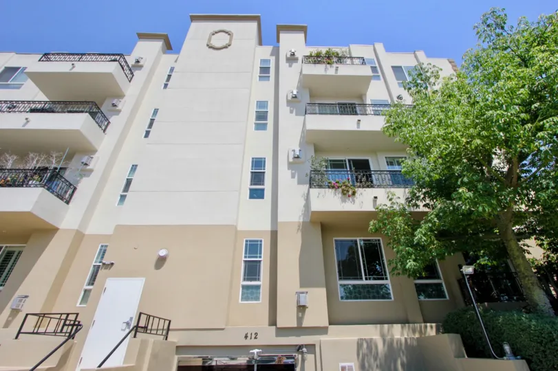 A beautiful apartment complex surrounded by trees. The balconies look spacious and the building looks like it's very well maintained.