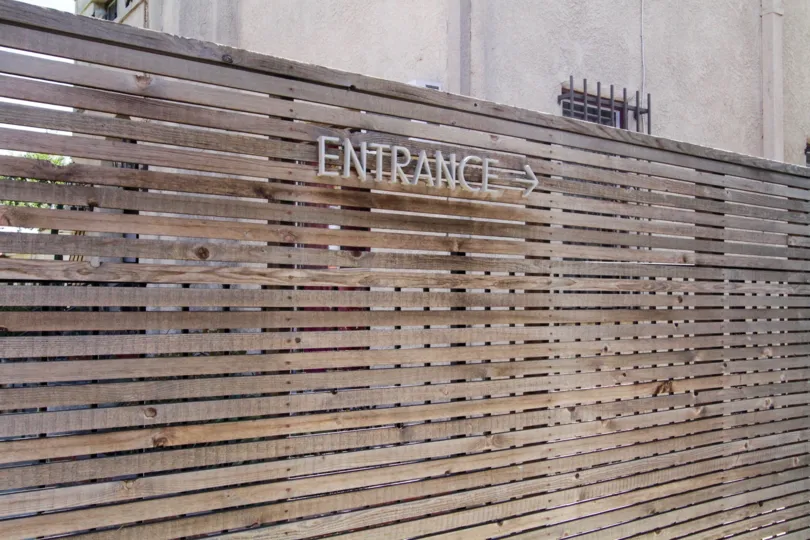 The word entrance with an arrow pointing at the direction to 611 N Bronson