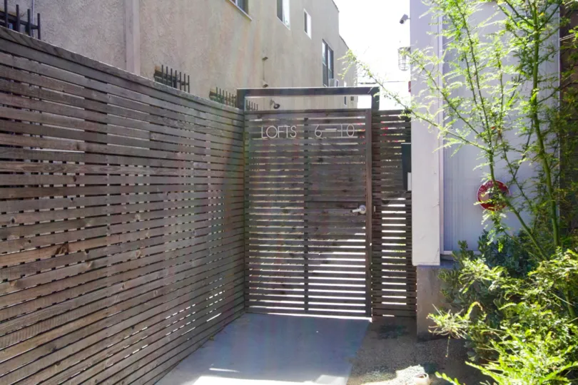 A wooden gate leads residence to units at 611 N Bronson