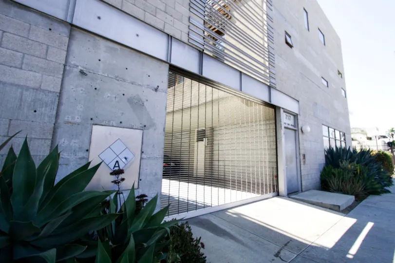 A metal gate leads to the parking are of Cahuenga Lofts