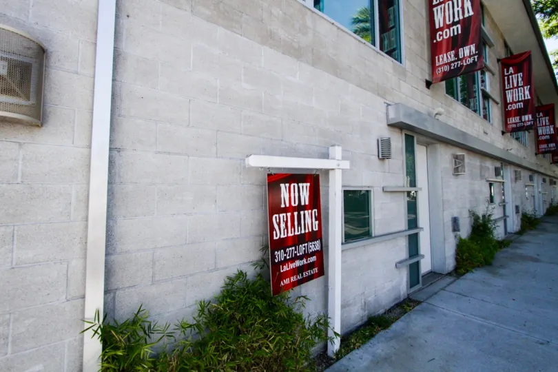 A sidewalk view of Highland Lofts showing several banners advertising it as a live work building
